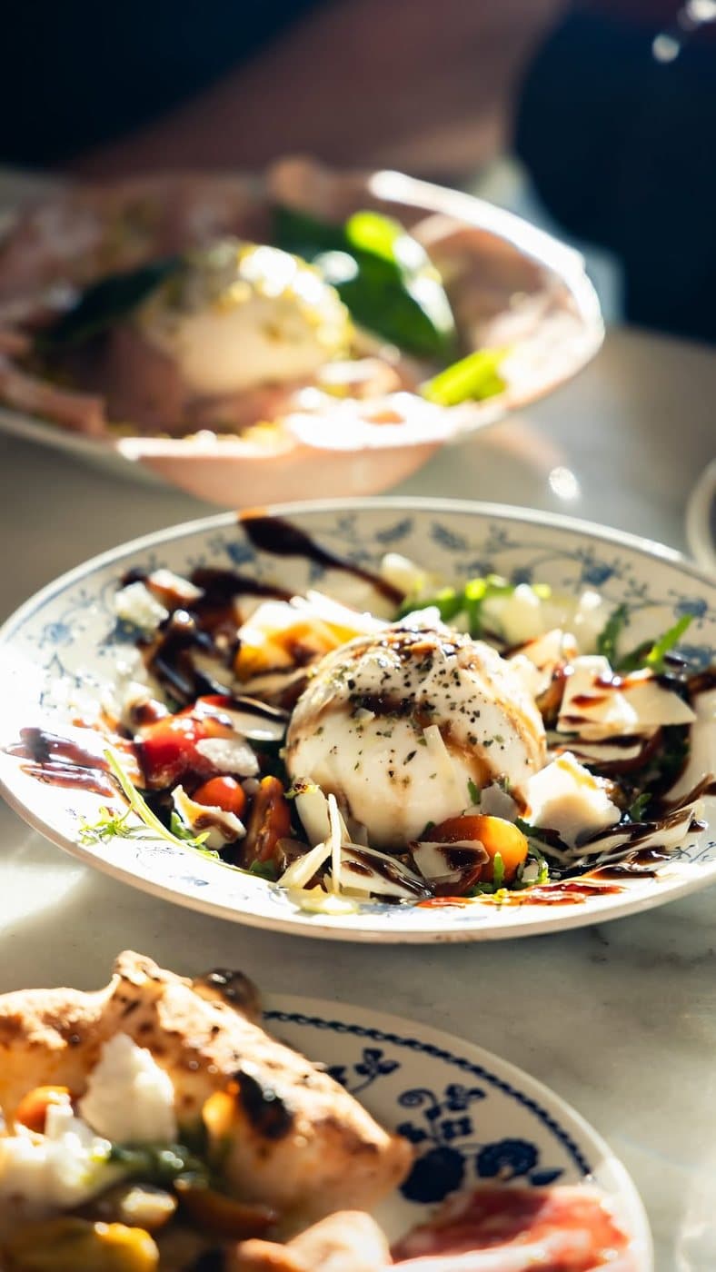 Burrata, tomates et crème balsamique dans une assiette peinte